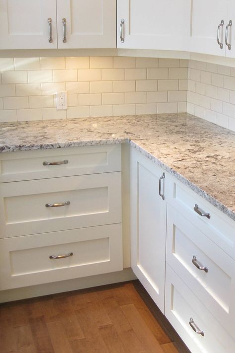 White Cabinet With Granite Countertops, Kitchen Flooring Ideas With Off White Cabinets, Off White Cabinet Backsplash, Whisper White Granite Countertops, White Cabinets White Backsplash Kitchen, White Cabinets With Wood Floor, Salinas Granite Countertops, White Kitchen Cabinets With Dark Granite Countertops, White Kitchen Cabinets With Farmhouse Sink