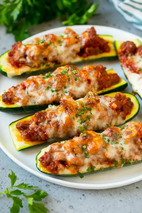 A plate of stuffed zucchini boats filled with a savory meat sauce and topped with mozzarella cheese. Zucchini Boat Recipes, Sommer Mad, Stuffed Zucchini Boats, Zucchini Stuffed, Sausage Stuffed Zucchini, Zucchini Pizzas, Stuffed Zucchini, Diner Recept, God Mad