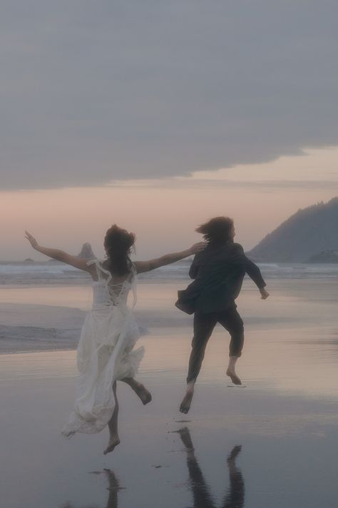 Couple runs across Cannon Beach with a beautiful sunset ahead of them. Beach Couple Photoshoot, Cloudy Evening, Oregon Sunset, Cloudy Beach, Couples Beach Photoshoot, Beach Rain, Rain Photo, Cannon Beach Oregon, Beach Couple