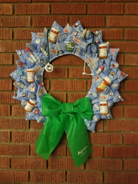 This medical themed wreath is made from disposable face masks, empty medicine bottles, Band-Aids, etc. The bow is made from a physical therapy resistance band. Hospital Christmas Decor, Medical Office Christmas Decorations, Hospital Christmas, Christmas Reef, Christmas Door Decorating Contest, Work Decor, Door Decorating Contest, Door Decorating, Bottle Ideas