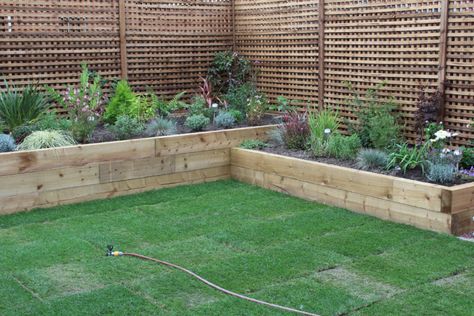 Timber Sleeper Garden Bed, Sleeper Flower Bed Ideas, Corner Raised Flower Beds, Sleeper Beds Garden, Sleeper Flower Beds, Corner Garden Ideas Landscape Design, Raised Flower Beds Along Fence, Indian Stone Patio, Raised Beds Sleepers