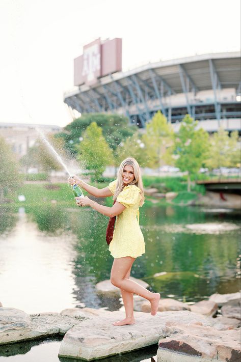 tamu senior grad popping champagne at aggie park woth yellow dress #tamu #aggie#seniorphotos Aggie Senior Pictures Texas A&m, Aggie Senior Pictures, Tamu Senior Pictures, Texas A&m Senior Pictures, A&m Senior Pictures, Tamu Graduation Pictures, Texas A&m Graduation Pictures, Aggie Graduation Pictures, Tamu Graduation