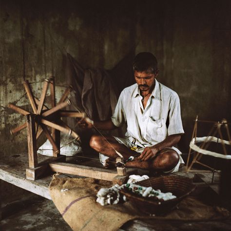 Picture of a man spinning cotton on a traditional wheel or charkha while sitting on the floor in his home in Bihar 1920 Home Decor, Spinning Cotton, Cotton Spinning, Tea Masala, Picture Of A Man, India Textiles, Handloom Weaver, Ancient Tools, Art Journal Tutorial