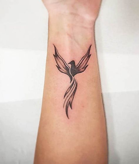 Black phoenix wrist tattoo by @mmarcadini Small Phoenix Tattoos For Women Wrist, Pheonix Tattoo Black Women, Black Pheonix Tattoo For Women, Phoenix Tattoo Small Minimalist, Phoenix Small Tattoo For Women, Phoenix Tattoo On Wrist, Ankle Phoenix Tattoo, Black Phoenix Tattoo Women, Phoenix Bird Tattoos Woman Arm