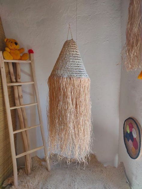 Handmade boho lampshade , suspension pendant light , straw wicker lampshade , palm leaf with raffia lamp . raffia and straw lampshade , boho pendant light , raffia lampshade , long raffia suspension light . the uniquely designed rattan lamp shade is handcrafted and will surely be an eye - catcher in the room you hang it in . Gives a very warm glow when lit . The raffia edge adds the perfect coastal boho look . this wonderful lampshade can be hung in the living room , nursery and hallway . Straw Lampshade, Boho Lampshade, Raffia Lamp, Raffia Lampshade, Boho Pendant Light, Wicker Lampshade, Rattan Lamp Shade, Home Lighting Design, Living Room Nursery