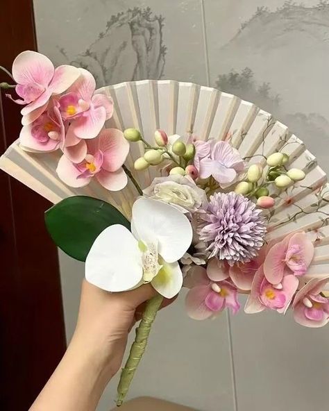 Stunning Folding Hand Fan Bouquet 🪭💐 Folding Hand Fans are also a must-have wedding favor. Enhance your wedding experience and optimize costs with our exclusive offers at Peonies. When you choose our premium wedding invitations, enjoy special discounts on a range of accessories, including gift boxes, vow booklets, welcome signs, menus, table numbers, thank you tags, and more. Contact us today for a complimentary consultation and personalized support. —————/-//-/————— 💒 𝗣𝗲𝗼𝗻𝗶𝗲𝘀 𝗪𝗲𝗱𝗱𝗶𝗻𝗴 𝗣𝗿𝗶... Chinese Wedding Flowers, Red And Yellow Wedding, Fan Bouquet, Fresh Bridal Bouquets, Faux Wedding Flowers, Yellow Wedding Decorations, Bridal Fan, Fan Ideas, Traditional Chinese Wedding