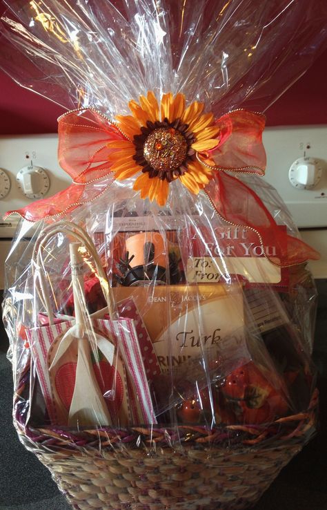 Thanksgiving Dinner Basket  Send this basket to someone you are thinking about at Thanksgiving giving them supplies for their Thanksgiving Dinner.   This basket includes: $25 Big Y Gift Card; Apple Bread Mix with Wooden Spoon; 	Rosemary Sage Dressing; A Silver Spoon Rest; Wine Glass Charms; Turkey Votive Candle Holder with Yankee Candle; Festive Paper Napkins; Turkey Brining Kit; Recipe Cards; Pumpkin Salt and Pepper Shakers  This basket for a great dinner sells for $100.00. Dinner Basket Ideas, Turkey Basket Ideas, Thanksgiving Dinner Basket, Thanksgiving Basket Ideas, Thanksgiving Food Basket, Liquor Basket, Sage Dressing, Turkey Brining, Thanksgiving Basket