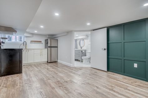 Creating A Basement Apartment | Before & After Photos - Katherine Budreau Renovated Basement, Hexagon Floor Tile, Basement Laundry Room Makeover, Green Accent Wall, White Ikea Kitchen, Small Basement Apartments, Hexagon Floor, Green Accent Walls, Basement Laundry Room