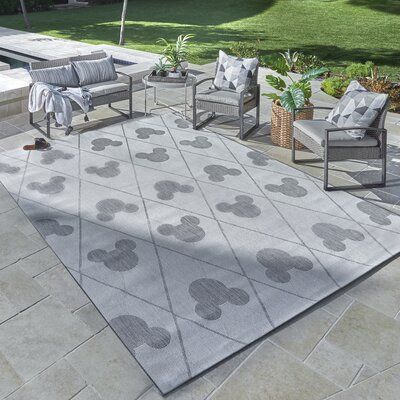 Bring the charm of Mickey Mouse to your indoor or outdoor spaces. This handsome Modern Argyle patterned rug in Gray with the iconic Mickey Mouse silhouette within the pattern. Bold and Fun, this rug works virtually anywhere. These flatweave rugs are power loomed using soft yet durable 100% Olefin yarns that are UV stabilized to resist fading, stain-resistant, and very easy to care for. Simply wash off with a garden hose, shake out the dust, or for indoors- vacuum. The precision Belgian looms cre Disney Outdoor Decor, Disney Rug, Outside Carpet, Casa Disney, Disney Garden, Mickey Mouse Silhouette, Disney Rooms, Flatweave Area Rug, Disney Home Decor