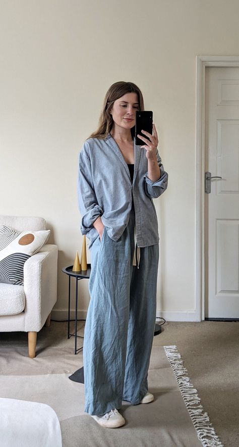 A woman stands in front of a mirror. She wears a light blue striped shirt, light blue drawstring trousers and white sneakers. Pyjamas Street Style, Pajama Style Outfit, Trousers With Sneakers, Trousers And Sneakers, Pyjamas Outfit, Pajama Outfit, Summer Outfits For Women, Blue Trousers, Fashion Board