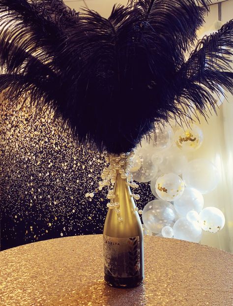 Gold and black ombré champagne bottle, black feathers and pearls Black And Gold 50th Anniversary Centerpieces, Black And Gold Anniversary Decorations, Roaring 20s Centerpieces, Gold Anniversary Decorations, 50th Anniversary Centerpieces, Black And Gold Centerpieces, Alcohol Gift Baskets, 70s Birthday, Mafia Party