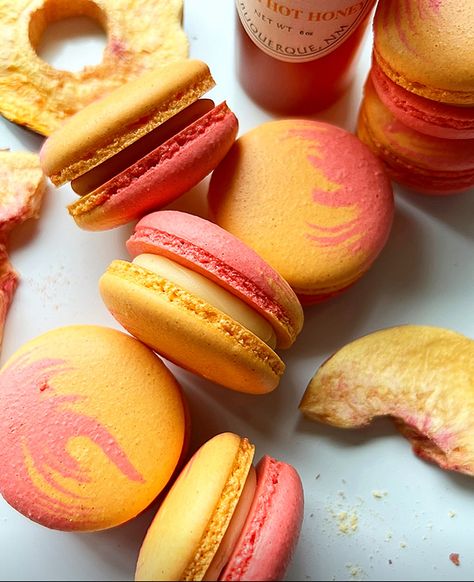 Red and yellow macarons designed to represent the colors of a fresh peach. There are freeze dried peaches on either side of the staggered macarons. A bottle of hot honey is just visible to the top right. Honey Macarons, Honey Making, Sliced Peaches, Peach Melba, French Patisserie, Fresh Peaches, Hot Honey, Joyous Celebration, Tea Sets