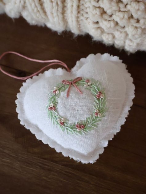 This darling embroidered stuffed hanging heart makes for the perfect shabby chic holiday decor. Wreath is embroidered with a blend of light green and white cotton threads, while small baubles are embroidered with beige and gold rose colors along with bow and string. Sewn with 100% white linen fabric, this heart can be used to hang on your Christmas tree, door, or simply add it to your wall decor. No matter where you decide to hang it, it'll certainly bring warmth and beauty to your space. Measur Embroidered Christmas Gifts, Handkerchief Quilt, Embroidery Christmas Ornaments, Heart Christmas Tree, Shabby Chic Christmas Ornaments, Christmas Tree Door, Embroidered Ornaments, Embroidered Christmas Ornaments, Sewn Christmas Ornaments