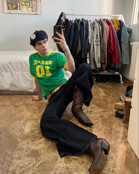 mirror selfie of me, Daniel Grant wearing a brasil tee with flared pants and cowboy boots Cowboy Boots Outfit Aesthetic Men, Black Cowboy Boots Outfit Men, Butch Cowboy, Pants Men Aesthetic, Aesthetic Poses For Men, Cowboy Boots Men Outfit, Cowboy Boots Outfit Mens, Flared Pants Men, Flare Pants Men