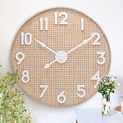 Add style to your decor with this Oversized Wicker Wall Clock. Handcrafted of bamboo, this round clock features a neutral coloured frame, a woven clock face with some decorative distressing, along with big white numeral markings and white clock hands. Perfect accent decor for a kitchen, dining room, living room, bedroom, foyer, sunroom or office. Battery required but not included. | Bay Isle Home™ Oversized 31.69" Bamboo Wicker Wall Clock Brown, Solid Wood | C100133062 | Wayfair Canada Bedroom Clock Ideas, Boho Clock, Bedroom Clock, Bedroom Clocks, Big Clock, Clock Ideas, Boho Mid Century, Wicker Wall, White Clocks