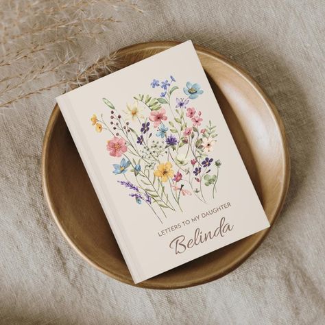 This beautiful Letters to my daughter Hardcover Personalized Notebook Wildflower, this beautiful floral journal a special place to write letters to your granddaughter as you watch her grow up. DETAILS  ⋒ Hardcover Journal Size 5.75" x 8" (14.5 x 20.5cm | A5) ⋒ 150 lined pages (75 sheets) ⋒ Matte finish ⋒ Ruled lined pages ⋒Casewrap binding ⋒ Pages are perforated Note: 0.5"x0.5" production barcode visible on the back cover DEVICES Please note that the colors may be slightly different from the final printed product due to various screen resolutions and color depths. REFUNDS & EXCHANGES Each notebook is made-to-order so returns are not accepted. Please notify me within 48 hours of delivery if there are any issues with your order and I would be happy to help! ⋒ All our items are custom printed Letters To The Bride, Bridal Shower Guest Book, Beautiful Letters, Floral Journal, Letter To My Daughter, Write Letters, Keepsake Journal, Dear Daughter, Bride Book