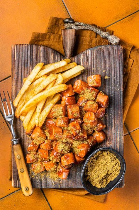 Curried sausage currywurst meal, curry wurst with french fry served on a wooden board. Orange background. Top view royalty free stock photography Curry Wurst, Curried Sausages, General Ideas, French Fry, Orange Background, Stock Photography Free, Wooden Board, French Fries, View Image