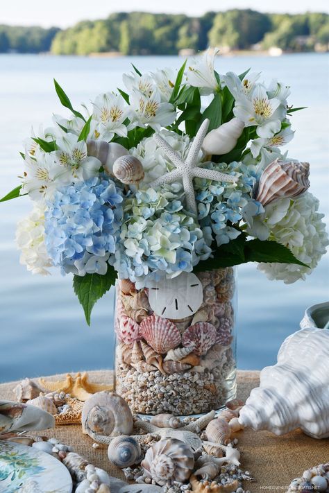 DIY Floral Arrangement with Shells for Seaside-inspired tablescape #lake #diy #flowerarrangement #seashells #beach #tablescape #tablesetting #summer ©homeiswheretheboatis.net Seashells In Glass Containers, Nautical Flower Arrangements, Coastal Flower Arrangements, Coastal Floral Arrangements, Beach Flower Arrangements, Seashell Arrangements, 222 Design, Nautical Flowers, Coastal Centerpiece Ideas