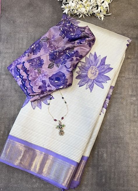 Mila cream lilac kanchipuram silk saree - Milas are as much about the weave as they are about the hand prints and textures that happen as a result of it. This extraordinary Kai Korvai pure Kanchipuram silk saree showcases diagonal cream and grey woven stripes across the body, complemented by a subtle yet substantial pure zari handwoven border and pallu in lilac. Adorned with beautiful purple sunflowers in shaded colors handprinted onto this magnificent saree, it exudes an exquisite contemporary touch, making it a versatile and one-of-a-kind choice for your wardrobe. To view more similar milas, pls click on https://aavaranaa.com/product-tag/mila/ Purple Contrast Color Combinations Dress, Saari Collection, Purple Contrast Color, Normal Saree, Purple Sunflowers, Mangalagiri Pattu Sarees, Aesthetic Saree, Saree Color Combinations, Lenin Sarees