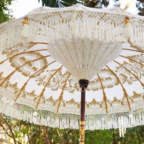 This spectacular fringed, tasseled and ornamented umbrella is known as “tedung” in Balinese dialect, which means “to guard.” Entirely handcrafted in Bali—from the carved pole to the intricately hand-gilded canopy—each umbrella is one of a kind and takes 10 days to create. Often used  in its native land for festive ceremonies and parades in colors to reflect the occasion. In this case, white represents purity, peace and knowledge. Bali Umbrella, Balinese Garden, Egg Decor, Garden Parasol, Garden Parasols, Garden Umbrella, Umbrella Designs, Luxury Garden, Umbrellas Parasols