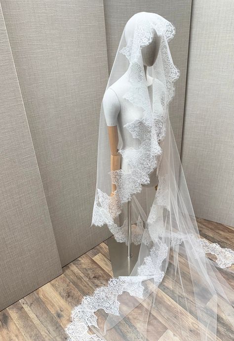 "This grand luxurious mantilla style veil features feminine vintage inspired Chantilly lace beautifully framing the face. This veil is made in the wider width insuring an elegant drape. The veil is secured in your hair with the comb on top of your head. The veil in the photos is a cathedral length and measures 110\" long from the hair comb to the bottom of the veil. Other lengths are available as well. The color of the veil is soft white and will compliment white, off white or light ivory dresses. * RETURN POLICY - We do not accept returns for a refund as all of out items are made to order. But please contact us if you are having an issue with your order. - We do accept exchanges. You can exchange your items for something else in our shop. The items you would like to exchange should be shi Long Veil Wedding Dress, Spanish Veil, Lace Trim Veil, Chantilly Lace Trim, Lace Trimmed Veil, Spanish Mantilla, Mexican Lace, Catholic Veil, Veil Long