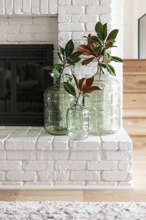 Small Chimney Decor Living Room, Glass Carboy Decor, Large Glass Bottles Decor Ideas, Glass Water Jug Decor Ideas, Green Bottle Decor, Large Glass Jugs Decor Ideas, Glass Jug Decor, Green Accents Living Room, Monotone Room