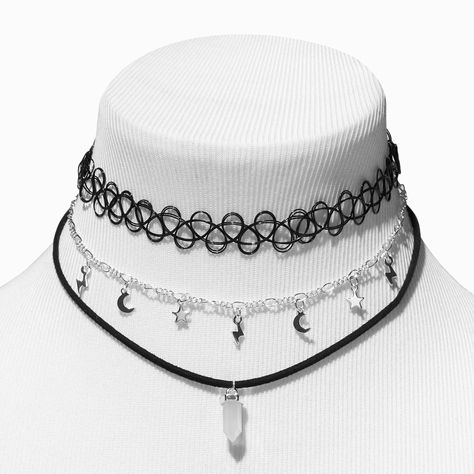 Complete your look with this choker set! It includes a stretch-fit black tattoo-style choker, a silver-tone figaro chain with celestial charms, and a black cord necklace with a white mystical gem. Layer them up for an on-trend look or wear them separately for a more subtle vibe.Pack Size: 3 Finish: Silver-tone Length: 12 + 3 in. extender / 30.48 + 7.62 cm. extender Closure: Lobster clasp, Stretch fit Material: Metal - Claire's White Mystical Gem, Celestial, & Black Tattoo Choker Necklaces - 3 Pa Choker Necklace Goth, Goth Wishlist, Emo Choker, Mystic Fashion, 2010 Accessories, Chokers Black, Gothic Icons, Goth Choker Necklaces, Grunge Chokers