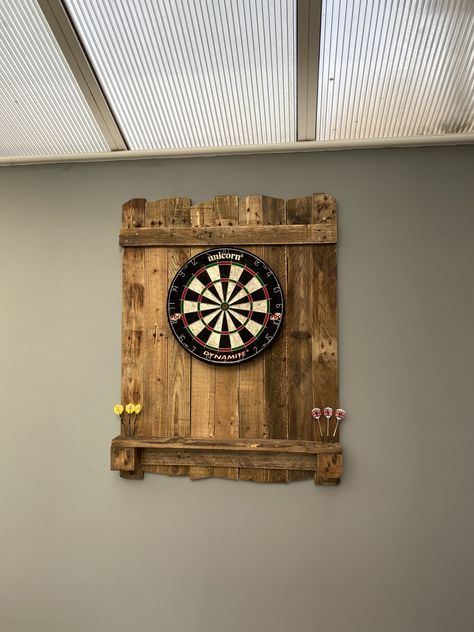 A dart board mounted on some pallet wood. Description complete. Pallet Dart Board Wall, Wooden Dart Board, Pallet Wood Dart Board Wall, Rustic Dart Board Wall, Diy Dart Board Backing, Wood Dart Board, Scaffold Boards, Dart Board, Games Room