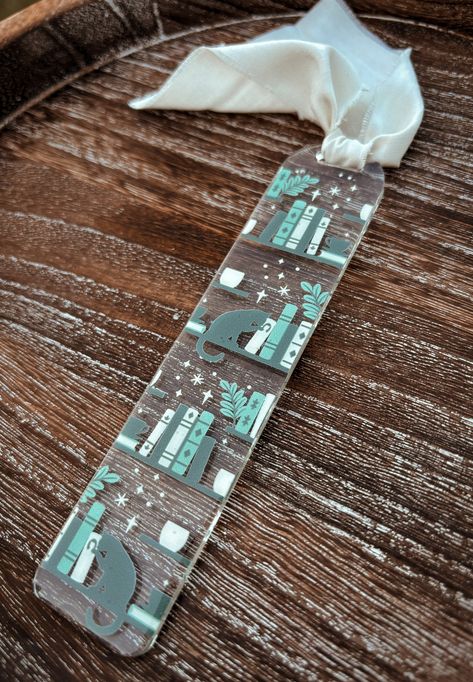 Bookmark details: ✔️1 acrylic bookmark with vinyl design.  ✔️Design is made with high quality, permanent adhesive vinyl & sealed with clear resin ✔️Chiffon ribbon is included in purchase.  ✔️Bookmark measures approximately 5.5" x 1.25". All items are made to order so shipping times may vary. Thank you! Clear Acrylic Bookmarks, Diy Resin Bookmarks, Diy Acrylic Bookmark, Acrylic Bookmarks Cricut, Cricut Bookmark Ideas, Acrylic Bookmark Ideas, Clear Bookmarks, Cat Library, Library Bookmarks