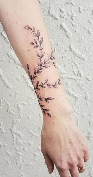 <<Check out more Vine tattoos #tattoomenow #tattooideas #tattoodesigns #tattoos #vine Vine Sketch Tattoo, Vine Tattoos For Women On Wrist, Wrapped Ivy Tattoo, Feminine Arm Wrap Tattoo, Rose Vine Wrist Tattoo, Leaf Vine Drawing Tattoo, Vine Bicep Tattoos, Vines And Their Meanings, Greenery Tattoo Design