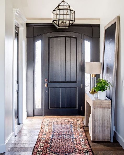 A dramatic entryway from our #lehiremodel Our client wanted a chalkboard hanging above the entry table so she could write notes to her kids as they headed out the door. We decided to go BIG and layer a large chalkboard with her entry table. We love how the layered wood table looks with the dark chalkboard. :: @lindsay_salazar_photography Studio Mcgee Living Room, Pintu Interior, Foyer Ideas Entryway, Front Door Interior, Front Door Entryway, Beautiful Entryways, Black Front Doors, Runner Rug Entryway, Farmhouse Entryway