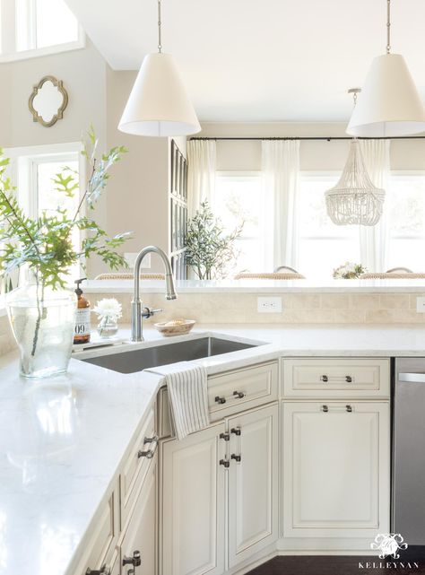 How to update and make a traditional kitchen with cream cabinets more modern and current (without painting the cabinets!) #kitchenideas #creamkitchen #creamcabinets #quartz #marble #counters #countertop #kitchencounter #kitchenisland  #kitchenmakeover #transitionalkitchen #classickitchen #goodmanpendants Cream Cabinets With White Countertops, Kitchen Countertops With Cream Cabinets, Coconut Cabinets Kitchens, Antique White Kitchen Cabinets With Quartz Countertops, Countertops With Cream Cabinets, Cream Cabinets White Countertop, Backsplash With Cream Cabinets, Kitchen With Cream Cabinets, Cream Kitchens