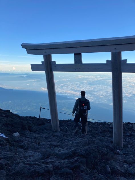 Man walks through a wooden Japanese Torii gate, an archway of wood. Beyond you can see an impressive view of mountains and sea from the top of Mount Fuji. Mountains Japan, Japan Hiking, Japan Mountains, Mt Fuji Japan, Japan Places, Japan Beach, Japan Tourist, Japanese Scenery, Fuji Japan