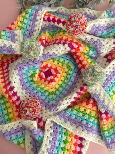 This beautiful array of rainbow shades on this stunning granny square blanket is guaranteed to bring a smile onto anyones face. And will bring a beautiful pop of colour into any room in your home each corner has got a corresponding pom pom to match the beautiful selection of rainbow colours throughout the actual blanket. They really do add that little extra character to the blanket 🌈.   🫧Washing instructions...Machine washable on a cool 30 degree wool cycle and of course handwashing is complet Crochet Pastel Rainbow Blanket, Rainbow Crochet Blanket Patterns, Granny Square Colours, Rainbow Granny Square Blanket, Rainbow Crochet Blanket Pattern, Rainbow Crochet Blanket, Crochet Blanket Rainbow, Granny Square Häkelanleitung, Spring Rainbow