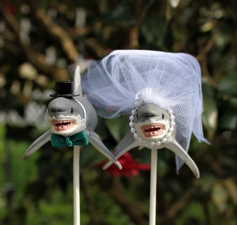 "Such a sweet wedding cake topper. Perfect for a beach or destination wedding. They make a very cute couple. They are Great White Sharks are one of the largest known mammals of the sea. Groom has a black hat and your chose of tie color with white or Ivory collar. Bride has a pearl necklace and Swarvoski crystal on her fin. Her head is adorned with a long white or ivory veil with ribbon flower. You also get the Mr. & Mrs. wooden heart Each shark measures 6 1/2\" x 2 5/8\" x 2 5/8\" tall. They Shark Wedding, Veil With Ribbon, Shark Cake Topper, Beach Wedding Cake Toppers, Shark Decor, Shark Pictures, Shark Cake, Ivory Veil, Beach Wedding Cake