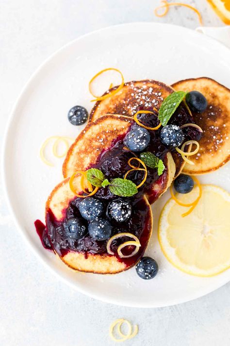 Plate of ricotta pancakes with blueberry sauce Blueberry Ricotta Pancakes, Blueberry Ricotta, Maple Syrup Glaze, Breakfast Presentation, Plating Food, Baking Breakfast, Lemon Ricotta Pancakes, Breakfast Photography, Mixer Recipes