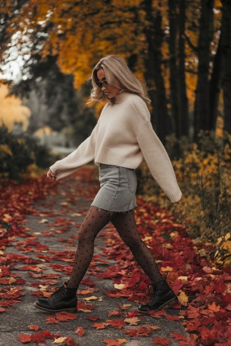 A fall outfit with a chunky cream sweater, denim skirt, women black polka dot stockings, and black Dr. Martens boots, set against a backdrop of autumn leaves Outfit With Sweater, Edgy Fall Outfits, Oversized Cream Sweater, Doc Martens Outfit, Autumn Look, Fall Photo, Varsity Jackets, Dr Martens Boots, Denim Skirt Women