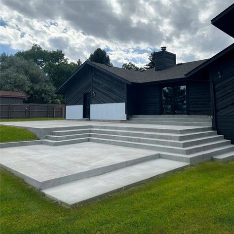 concrete-patio Raised Concrete Patio Ideas With Steps, Concrete Patio Steps From House, Concrete Patio Sloped Yard, Sloped Patio Ideas, Concrete Patio With Steps Down From House, Elevated Concrete Patio, Wide Patio Steps, Concrete Patio Ideas With Steps, Concrete Patio With Steps