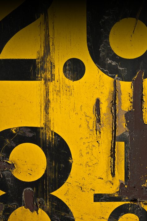 Worn yellow sign with black numbers and distressed paint.