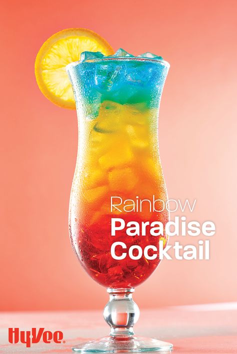 Sip on this layered summer cocktail while daydreaming of your next vacation. This simple rainbow drink recipe is made by slowly pouring in a combination of coconut rum, grenadine, and blue curacao. Cheers to patio happy hours everywhere! Cocktail Recipes Blue Curacao, Paradise Cocktail Recipe, Rainbow Mocktails Non Alcoholic, Pride Drink Recipes, Rainbow Paradise Cocktail, Rainbow Drinks Alcohol, Rainbow Cocktail Recipe, Moktail Non Alkohol, Pride Cocktail Recipes