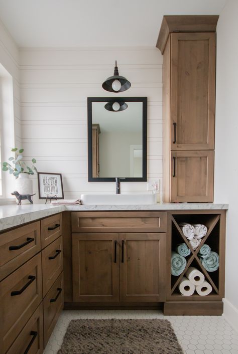 Create the perfect farmhouse bathroom with: wood cabinetry, marble styled countertops, white subway tile, and matte black accents! White Black Wood Bathroom, Brown Wood Bathroom, Black And White With Wood Accents, Black White And Brown Bathroom Ideas, Buffalo Decor, Black And White Bathroom With Natural Wood Vanity, White Bathroom With Wood Accents, Wood Bathroom Vanity With Gray Countertop, Brown And White Bathroom