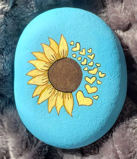 Rock Painting Ideas Blue, Dandelion Rock Painting Ideas, Diy Stone Painting, Sunflower Stone Painting, Painted Rocks Sun, Simple Stone Painting, Easy Rock Painting Ideas Simple Flowers, Sunflower Pebble Art, Rock Painting Ideas Black Background