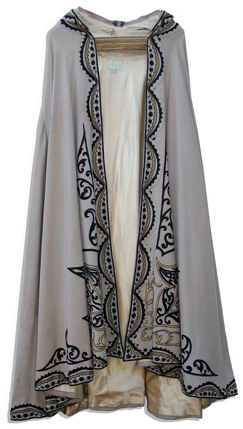 This beige woven cape is decorated with an embroidered design in black and gold thread running around the hemline, up the front and extending around the pointed hood, which culminates in a tassel. Cloak is fully lined in champagne silk. Worn by Anthony Quinn in Road To Morocco (1942) Cloak Ideas, Embroidered Cloak, Sergio Toppi, Silk Costume, Dnd Inspiration, Visual Clothing, Embroidered Cape, Retro Clothes, Clothing Board