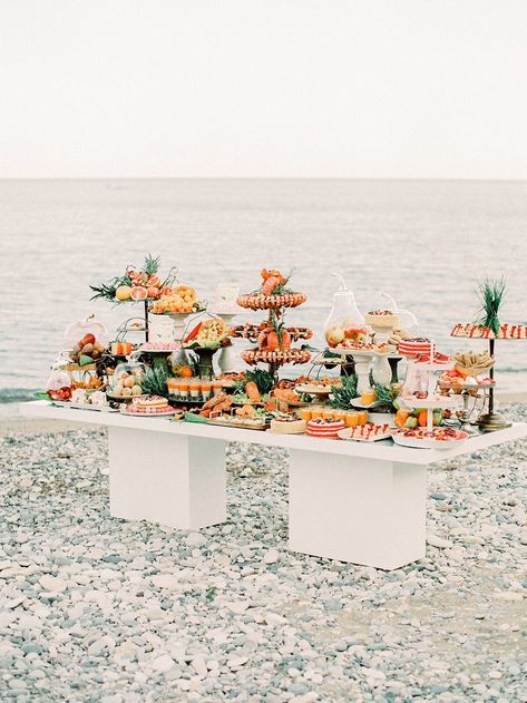 Hold up. You do not want to miss this pebbled coast wedding inspiration overflowing with with details in every shade of citrus. From the intimate shoreside table that sits beneath a dreamy cabana to the fluttery Berta gown with layers of romantic tulle, we are hooked on this vision forever. Color and modern whimsy forever! #ruffledblog Beach Catering Ideas, Wedding Food Beach Theme, Food For Beach Wedding, Beach Wedding Catering, Beach Wedding Food Stations, Wedding Food Seafood, Seafood Bar Wedding, Beach Wedding Appetizers, Wedding Food Beach