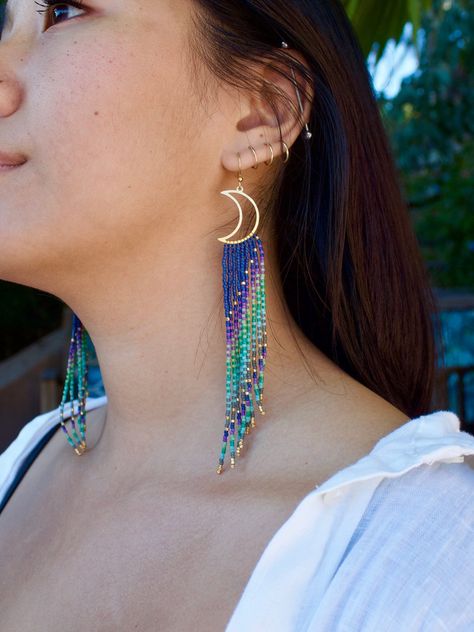 Beautiful, long statement piece earrings. Handmade, handwoven. Made with 100% raw brass moon charm and high quality Miyuki delica glass seed beads.  Ombré colors include shades of purple, blue and green. ⋄ Handwoven/handmade seed bead fringe earrings made with high quality Japanese Miyuki Delica glass beads ⋄ 100% raw brass ear wire (nickel free & hypoallergenic)         ⋄ PLEASE DIRECT MESSAGE me with any questions regarding ear wire material, other options ARE available upon request :) ⋄ 100% Earrings Handmade Beaded, Seed Bead Fringe Earrings, Bead Fringe Earrings, Seed Bead Projects, Blush Earrings, Bead Fringe, Striped Earrings, Beaded Fringe Earrings, Geometric Hoop Earrings