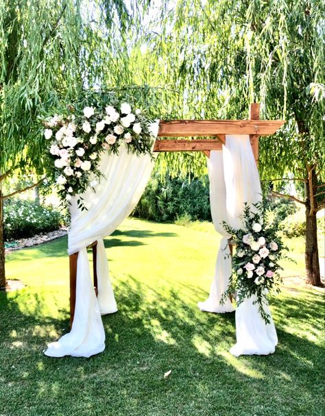 Wood arch fir wedding ceremony among the trees on grass. Decorated with flowers, greens and fabric. Wooden Wedding Arch With Flowers, Ceremony Wooden Arch, Wooden Wedding Arches, Wedding Arches Outdoors, Wedding Arches, Wedding Ceremony Arch, Wood Arch, Wedding Arch Flowers, Wooden Arch