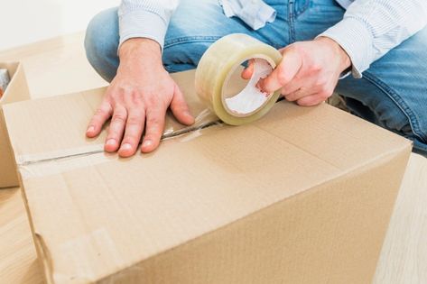 Young man sealing cardboard box with tap... | Premium Photo #Freepik #photo #people #house #circle #hand Office Tape, Acrylic Glue, Corrugated Carton, Moving Long Distance, Packaging Tape, Tape Dispenser, Packers And Movers, Packing Tape, Packaging Supplies