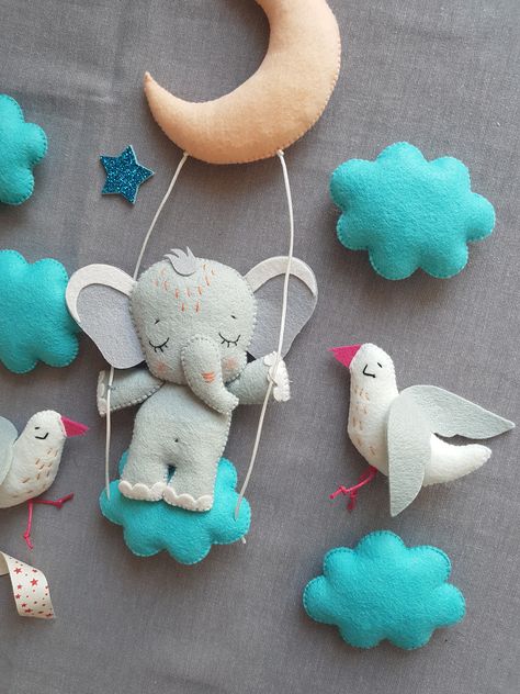 The theme of elephants on a mobile is not new at all for a long time, but I see it in my own way .... my baby elephant rides on a swing among the clouds, the moon and birds. Baby elephant is happy and calm, he has sweet dreams :) Please give him a heart💕 if you like this mobile! And if you have already fallen in love with him, he will gladly settle in your house! Elephant Mobile, Among The Clouds, Mobile Girl, Woodland Mobile, Elephant Ride, Baby Boy Mobile, Pom Pon, Mobile Hanging