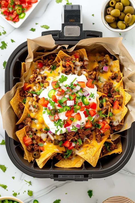 Grab these easy air fryer nachos while they’re hot! Between the taco-licious ground beef, juicy tomatoes, and gooey cheese, they’re not to be missed. Best Cheese For Nachos, Air Fryer Nachos, Ground Beef Nachos, Nachos Recipe Beef, How To Make Nachos, Loaded Nachos, Air Fryer Recipe, Nachos Beef, Yummy Healthy Snacks