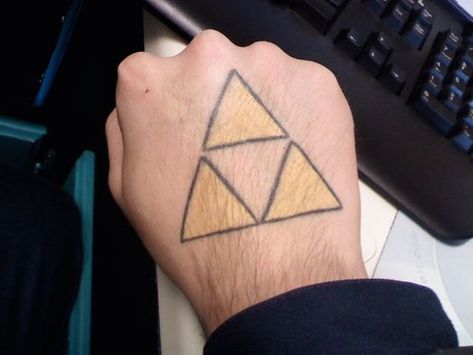 If you think about some legendary and recognizable ink the Triforce tattoo might grace your skin after reading this article. There is everything you need to know about this design. So let’s start! Zelda Triforce Tattoo, Triforce Tattoo, Courage Tattoos, Hand Tattoo Images, Legend Of Zelda Triforce, Zelda Tattoo, Zelda Triforce, Clever Tattoos, Face Painting Easy